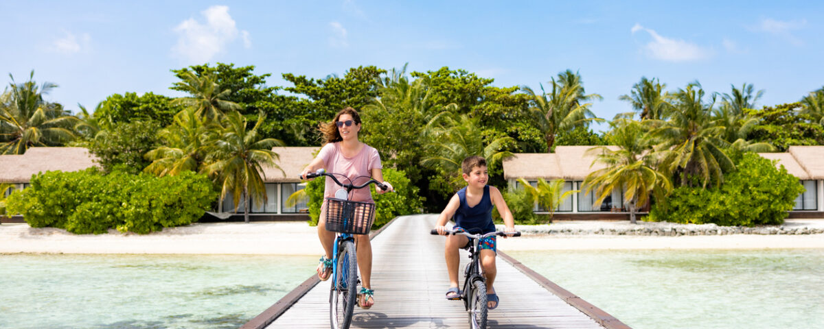 Exploring Maui with Kids: Mother and son riding their bikes on a walkway on an island